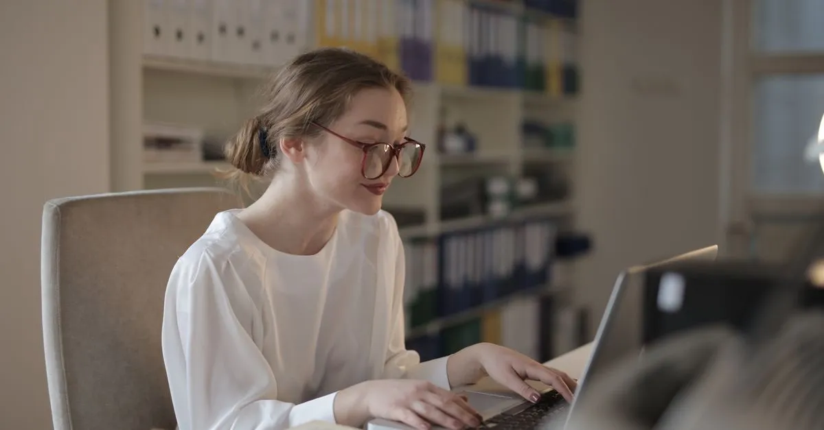 A small business owner working on a laptop with Microsoft 365 apps open in a bright office